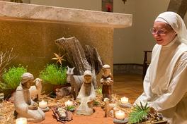 Sœur Marie-Aurélie devant une crèche préparée par les sœurs cisterciennes de Castagniers. 